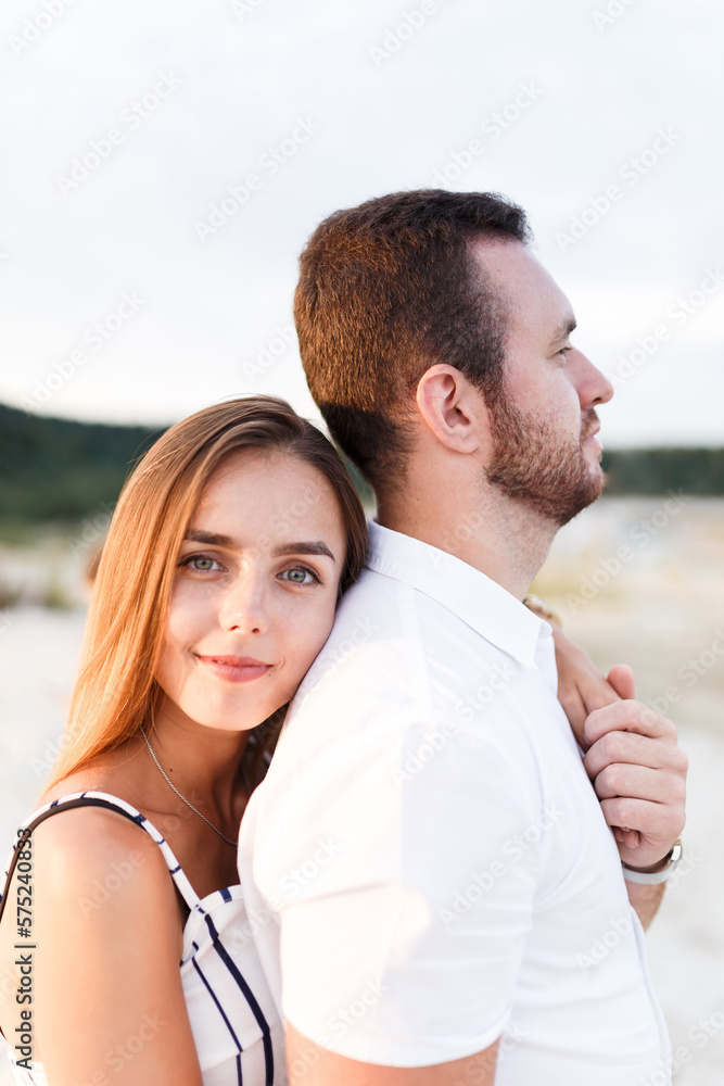 man and a woman are hugging on a sandy beach in summer man and a woman are hugging on a sandy beach in summer