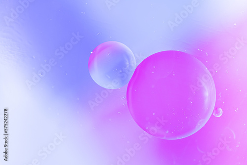 Abstract background in blue and violet soft tones. Macro drops of oil on the surface of the water. Delicate cosmetic background for advertising products. copy space.