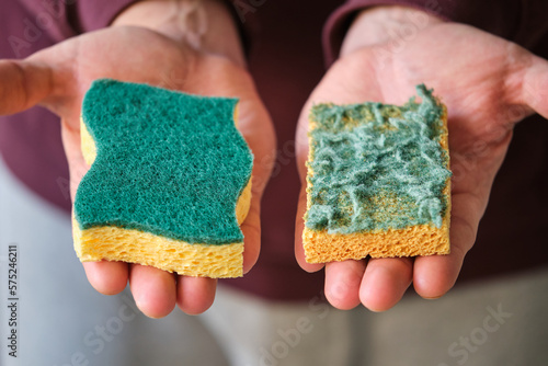 Obraz na płótnie Mens hands comparing new and old double-side cleaning scouring sponge. w salonie