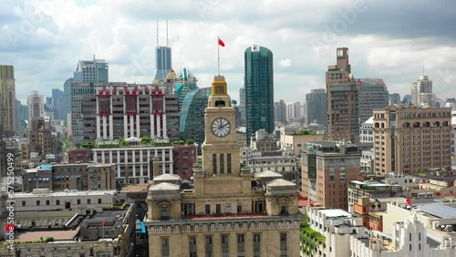 Aerial Panning Shot Of Clock On Custom House In Modern Residential City Under Cloudy Sky - Shanghai, China photo