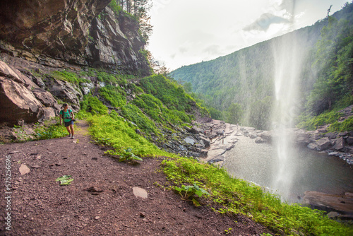 Hiker walks under Kaaterskill Falls in upstate New York. photo