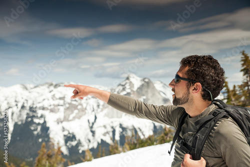 A backpacker points toward an adjacent mountin range. photo