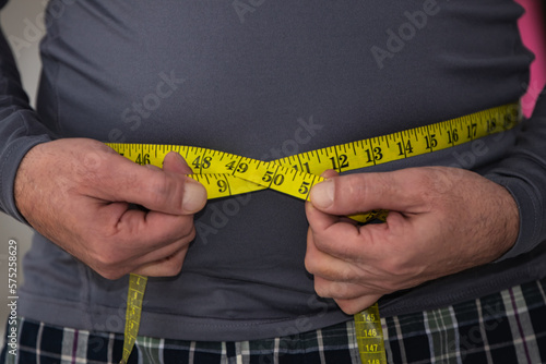 Photography man with tape measure around his belly