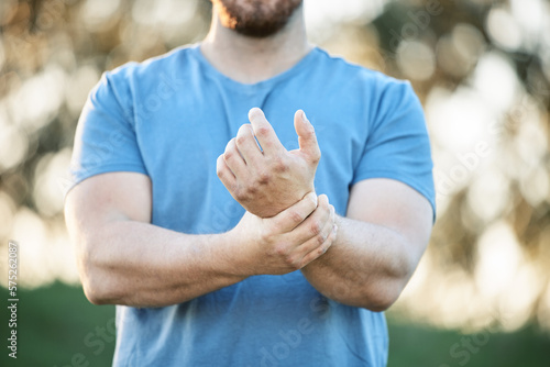 Injury, sports and man with wrist pain from a workout, exercise accident and sprain from cardio. Fitness, emergency and athlete with carpal tunnel syndrome, inflammation and injured arm from training photo
