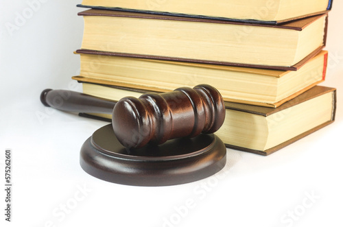 Abstract photo with wooden gavel and books with codes on white background