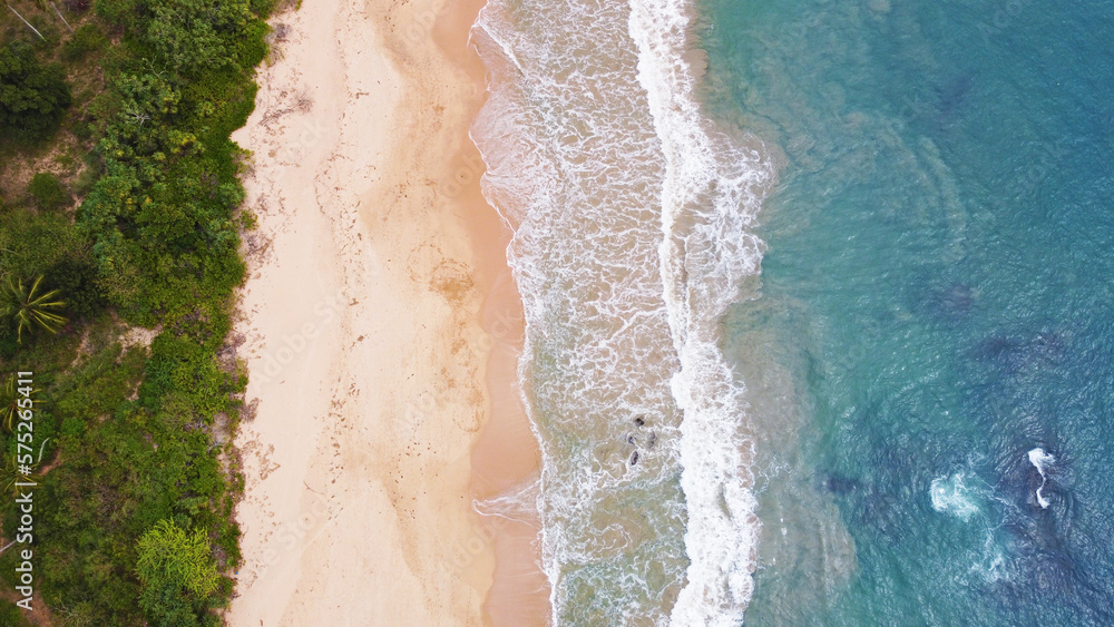 Aerial view of the ocean coast and sandy sea beach. Beautiful water background texture for tourism and advertising. Tropical coast