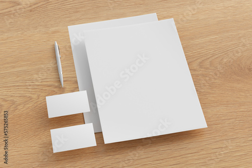 Blank corporate stationery set mockup with sheets of office paper, business cards and pen on wooden background. Branding mock up. Side view