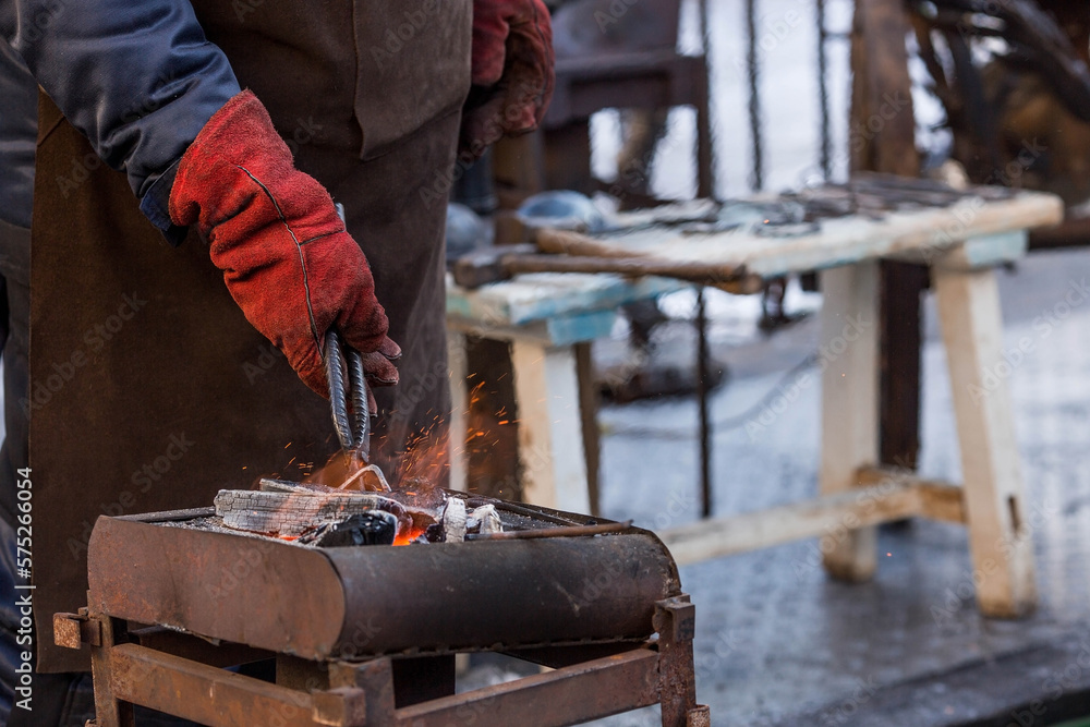 Moscow seasons. Traditional craft. The work of a blacksmith with metal at the celebration of Maslenitsa (Maslenitsa Week). Russian traditions. Tverskaya Street. Moscow. Russia Moscow seasons. Traditional craft. The work of a blacksmith with metal at the celebration of Maslenitsa (Maslenitsa Week). Russian traditions. Tverskaya Street. Moscow. Russia