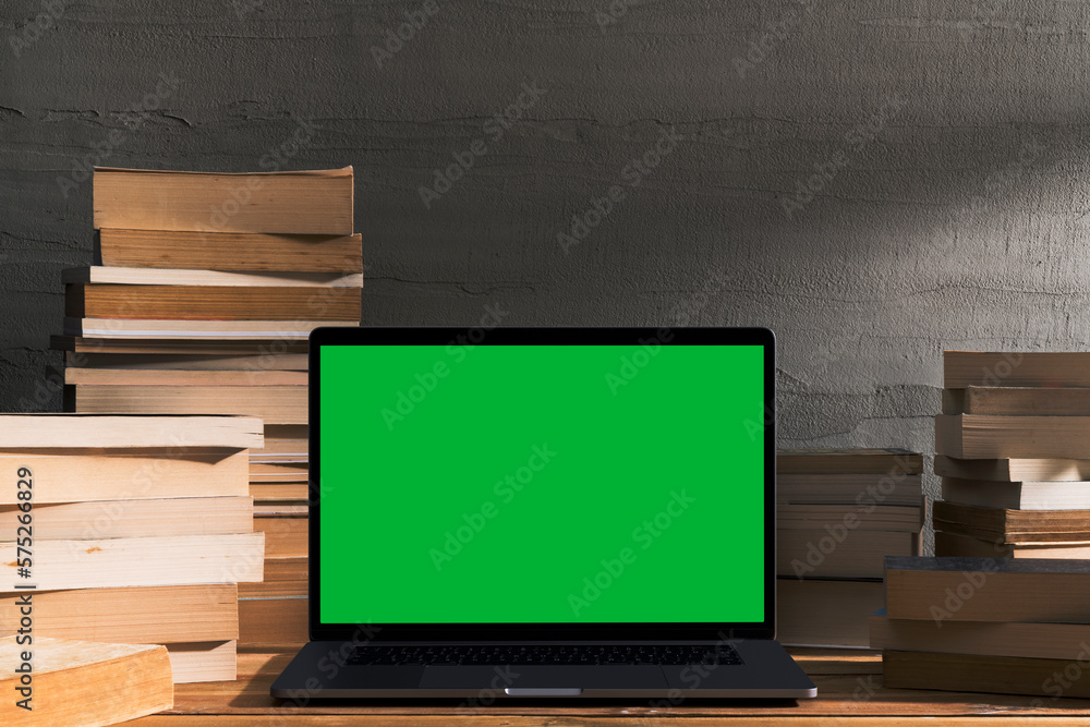 Chroma key green screen laptop on table with pile of books Chroma key green screen laptop on table with pile of books