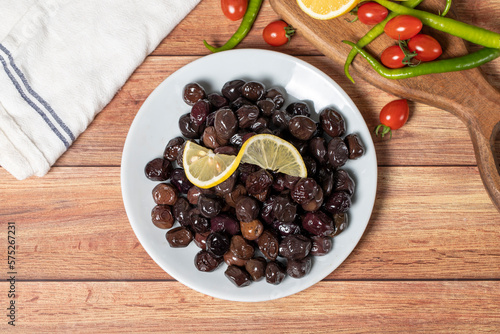 Black olive. Fermented olives and lemon slice in plate. Mediterranean flavors. Top view