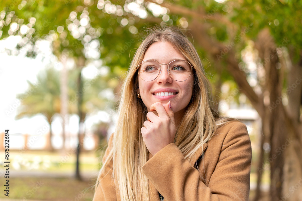 Young pretty blonde woman at outdoors looking to the side Young pretty blonde woman at outdoors looking to the side
