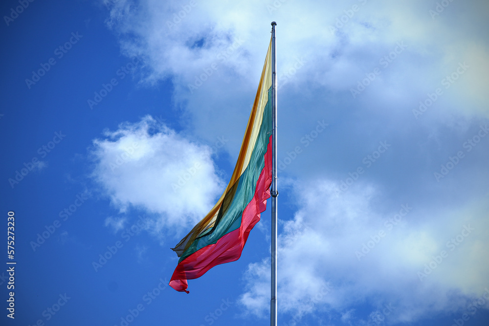Flag of Lithuania on blue sky with clouds background
