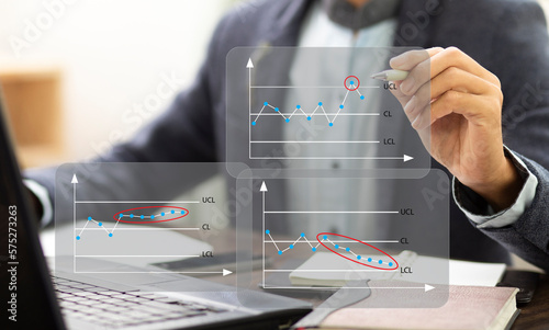 businessman or trainer write SPC chart control and analysis problem data in process  at workplace in office