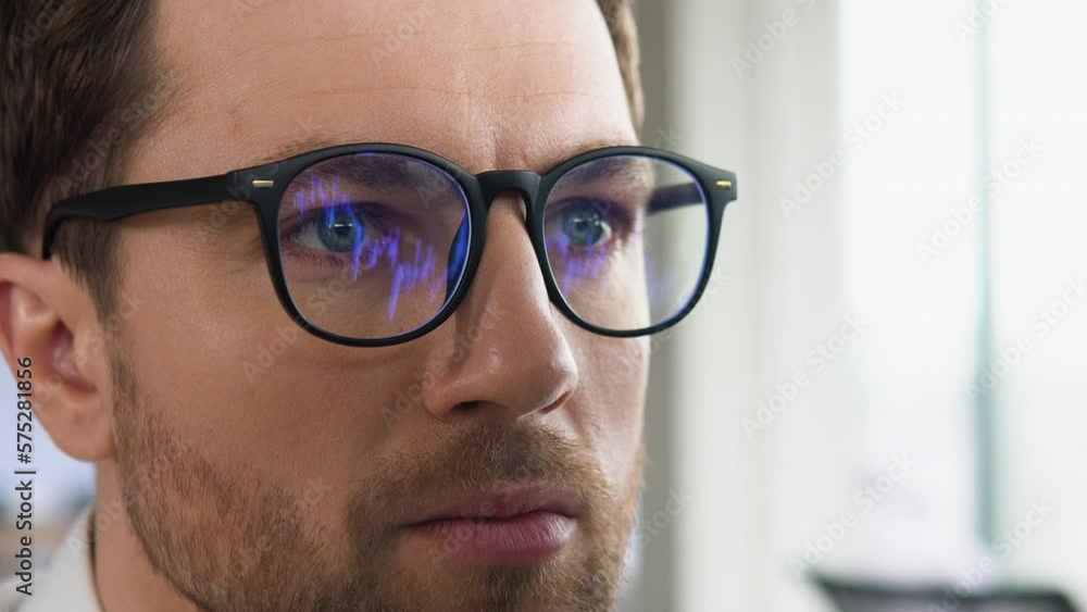 Crypto trader wearing eyeglasses working looking at computer screen reflecting in glasses analyzing online trading stock exchange market financial data charts. Close up eye in spectacles reflection Crypto trader wearing eyeglasses working looking at computer screen reflecting in glasses analyzing online trading stock exchange market financial data charts. Close up eye in spectacles reflection
