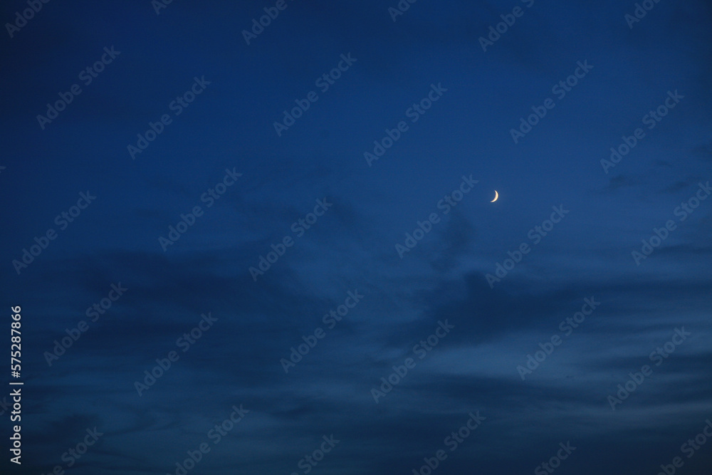 the crescent moon in the evening sky