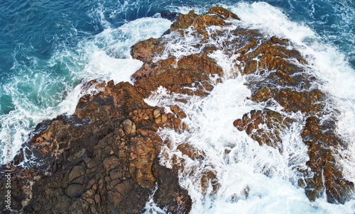 Aerial view of the sea rocks cliffs in the ocean. Beautiful sea wallpaper for tourism and advertising. Stormy landscape, drone photo