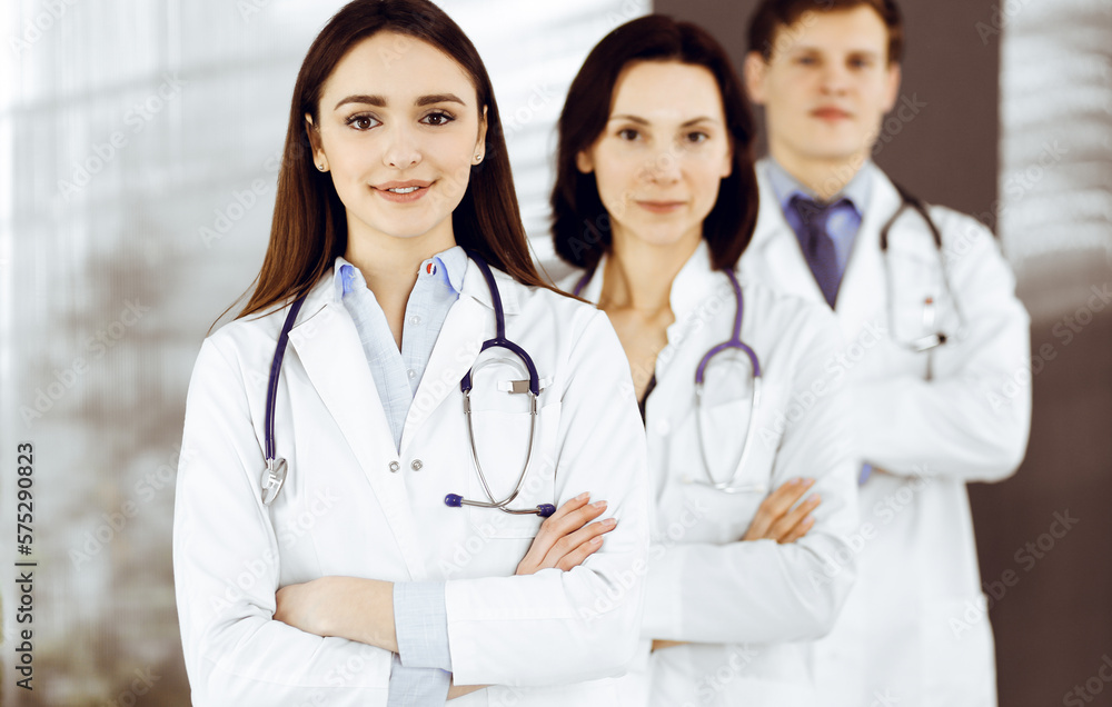 Group of young professional doctors is standing as a team with arms crossed in a hospital office and is ready to help patients. Medical help, insurance in health care Group of young professional doctors is standing as a team with arms crossed in a hospital office and is ready to help patients. Medical help, insurance in health care