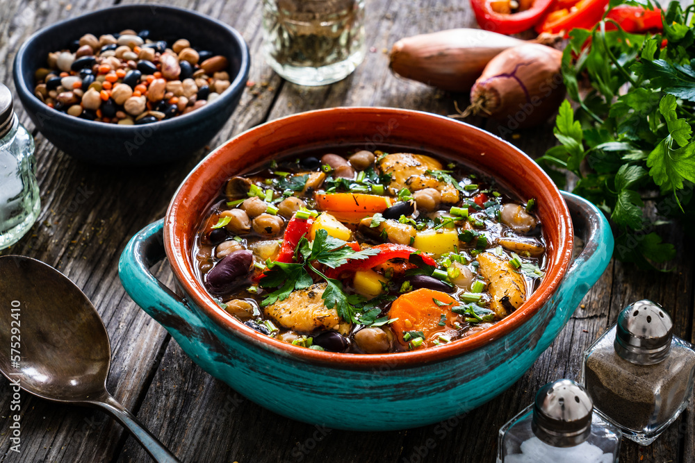 Delicious soup - cooked chicken breast boiled fresh vegetables, lentils, peas and chickpeas on wooden table
Delicious soup - cooked chicken breast boiled fresh vegetables, lentils, peas and chickpeas on wooden table