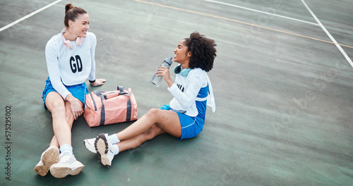 Netball, friendship and girls talking outdoor after a match, training or exercise on the court. Happy, friends and female athletes laughing, speaking and bonding together after a game or practice. © Anela R/peopleimages.com
