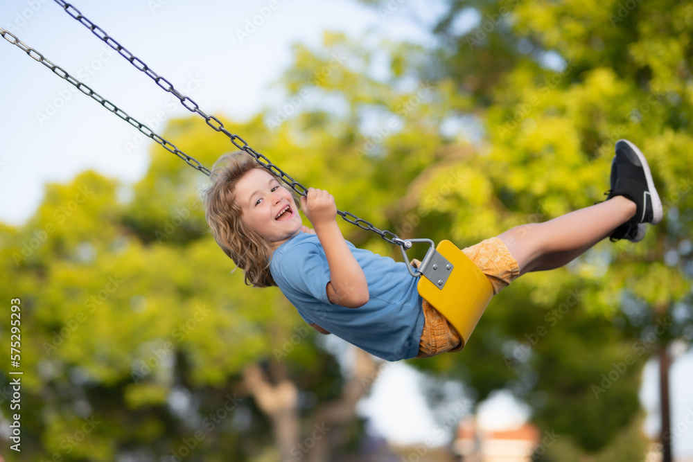 Little kid swinging portrait. Adorable child having fun on a swing on