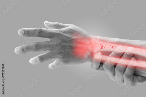 Obraz na płótnie A man massaging painful wrist on a gray background