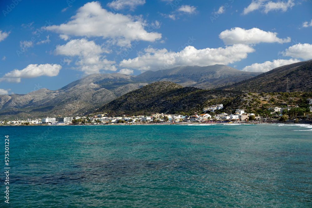 Aegean Sea in Crete. White clouds hang over the mountains. Azure water.	