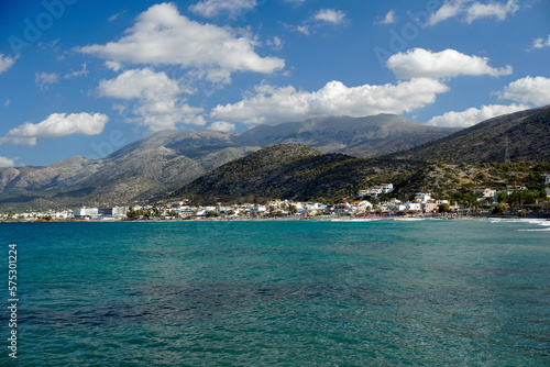 Aegean Sea in Crete. White clouds hang over the mountains. Azure water. 