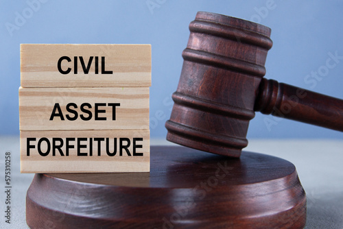 The words CIVIL ASSET FORFEITURE on wooden cubes against the background of the judge's gavel and stand. photo