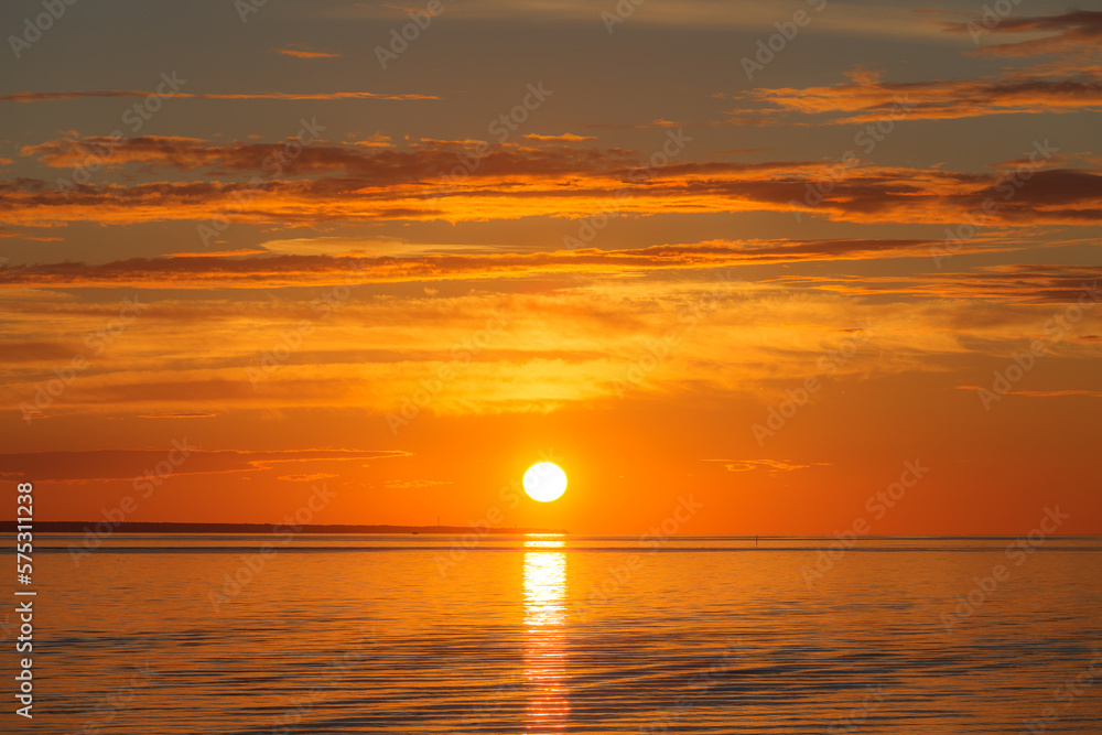 Sunset over sea, red colors, long clouds