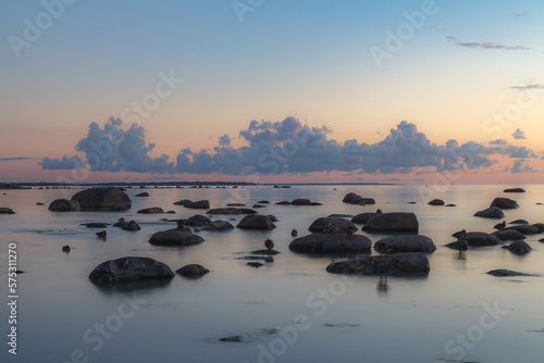 Red colored sky over a rocky seashore. Sunset landscape.