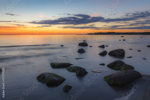 Red colored sky over a rocky seashore. Sunset landscape.
