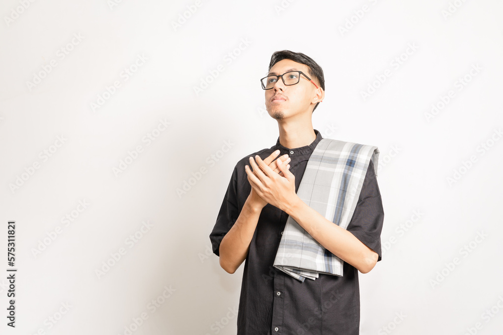 A male single model doing pray with his two hands held together and looking up. Indonesian or southeast asian. Studio photoshoot with white background. A male single model doing pray with his two hands held together and looking up. Indonesian or southeast asian. Studio photoshoot with white background.