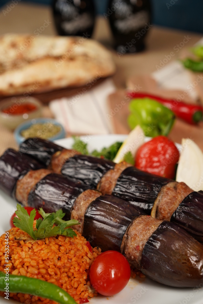 Traditional Turkish eggplant kebab or kebap meat food, appetizers, raki and salgam on table from top view in turkish restaurant.