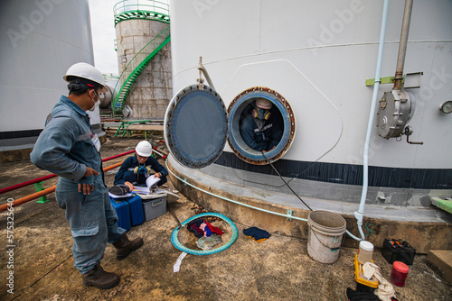 Male worker into the tank carbon chemical oil interface area confined space