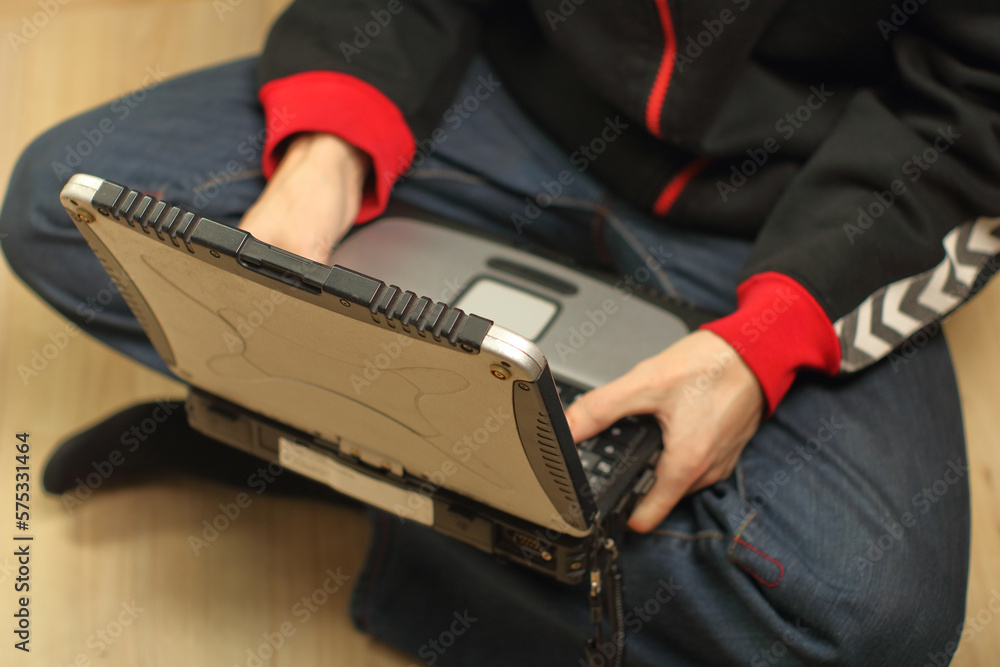 a person holding an old laptop