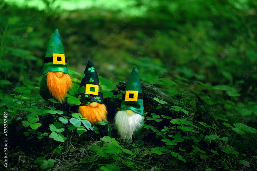 toy irish gnomes in mystery forest, abstract green natural background. magic friends dwarfs  and fantasy nature. fairy tale image. harmony beautiful spring or summer season. symbol of Ireland - obrazy, fototapety, plakaty 