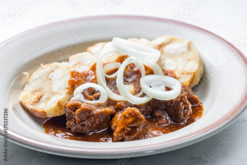 beef goulash with onion rings and dumplings photo