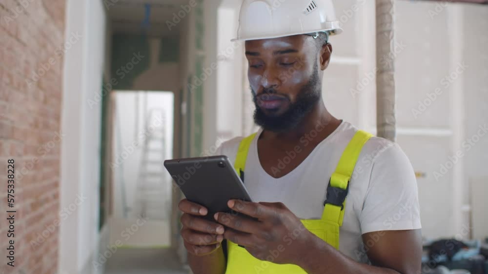 African-American with tablet pc computer and equipment at construction site. Realtime African-American with tablet pc computer and equipment at construction site. Realtime