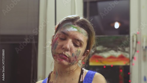 Portrait of a female artist. Girl with clumsy clorful painted face. Dancing. photo
