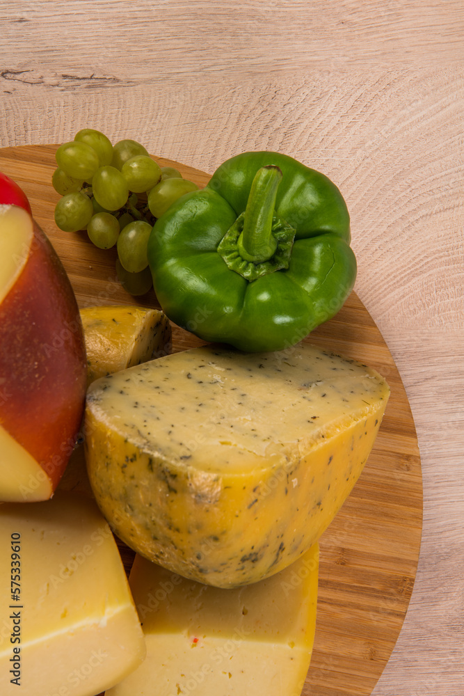 Bosnian traditional cheese served on a wooden container with peppers, parade and onions isolated on a white background Bosnian traditional cheese served on a wooden container with peppers, parade and onions isolated on a white background