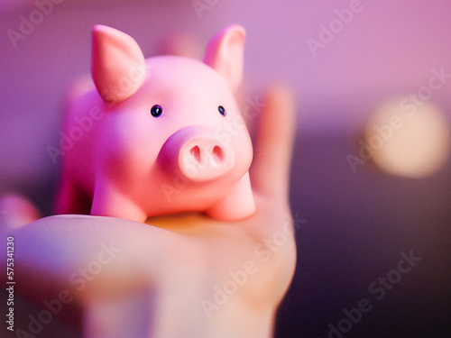 Tirelire en forme de cochon posée sur une main photo
