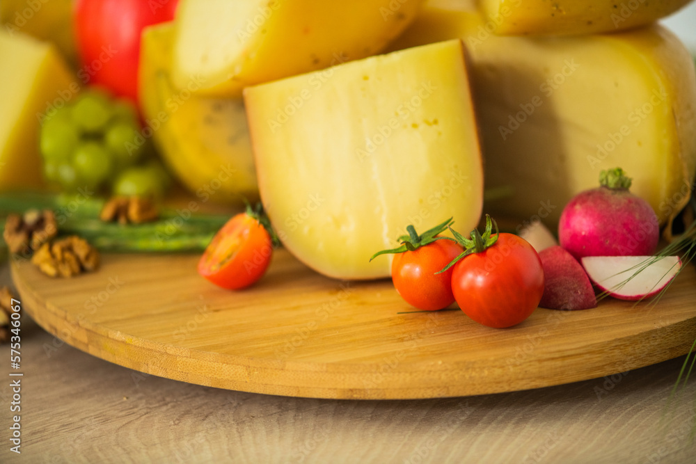Bosnian traditional cheese served on a wooden container with peppers, parade and onions isolated on a white background Bosnian traditional cheese served on a wooden container with peppers, parade and onions isolated on a white background