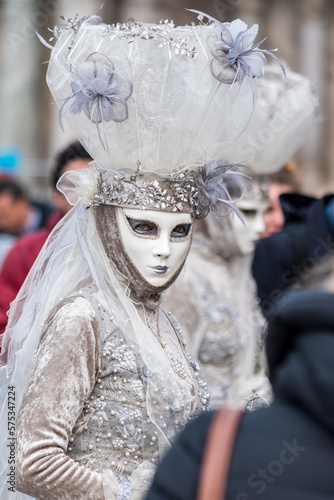 Beautiful candid white carnival mask. Mask that looks at me with blue eyes, covered in pearls and flowers. Venetian masks with sensuality and extravagance. © Patrick