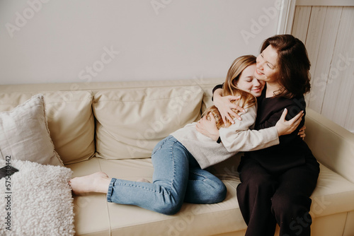 Teenage daughter affectionately hugging her mother