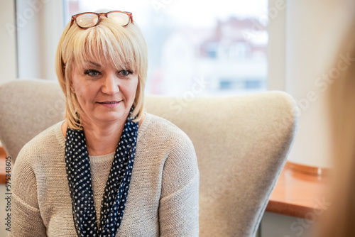 Two women of different generations are talking at a business meeting in an elegant office