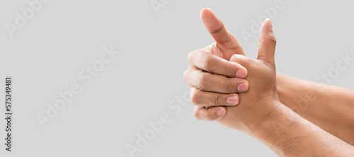 A man cracking their knuckles, On a gray background. photo