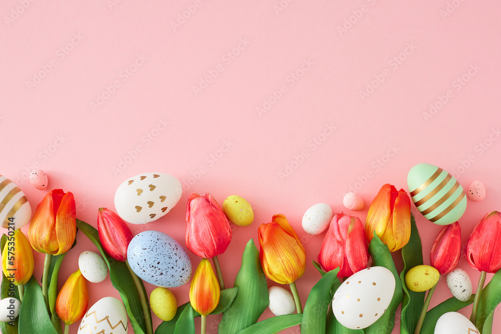 Easter concept. Top view photo of red tulips flowers colorful eggs on isolated pastel pink background with empty space. Holiday card idea Easter concept. Top view photo of red tulips flowers colorful eggs on isolated pastel pink background with empty space. Holiday card idea