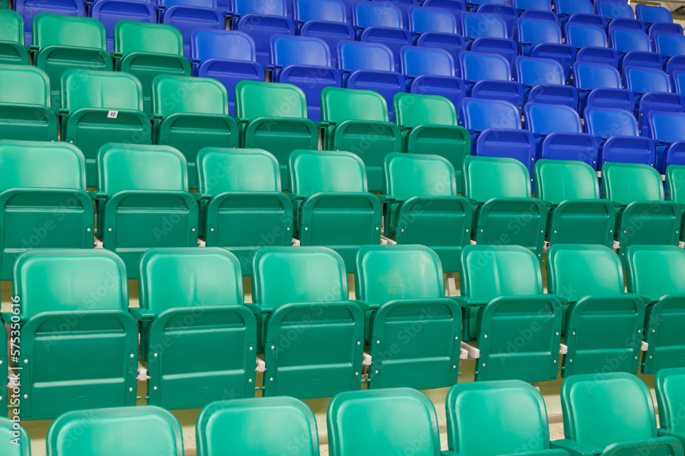 Green and blue plastic spectator stadium seats. Nobody, empty rows