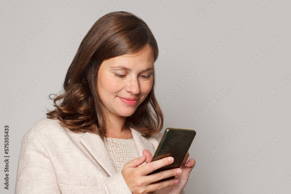 Smiling young brunette woman using mobile phone, typing sms message, portrait Smiling young brunette woman using mobile phone, typing sms message, portrait