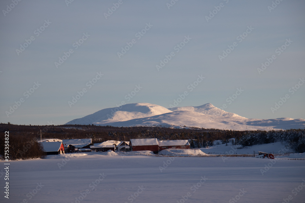 Schneelandschaft mit Bergen und Häusern in Norwegen